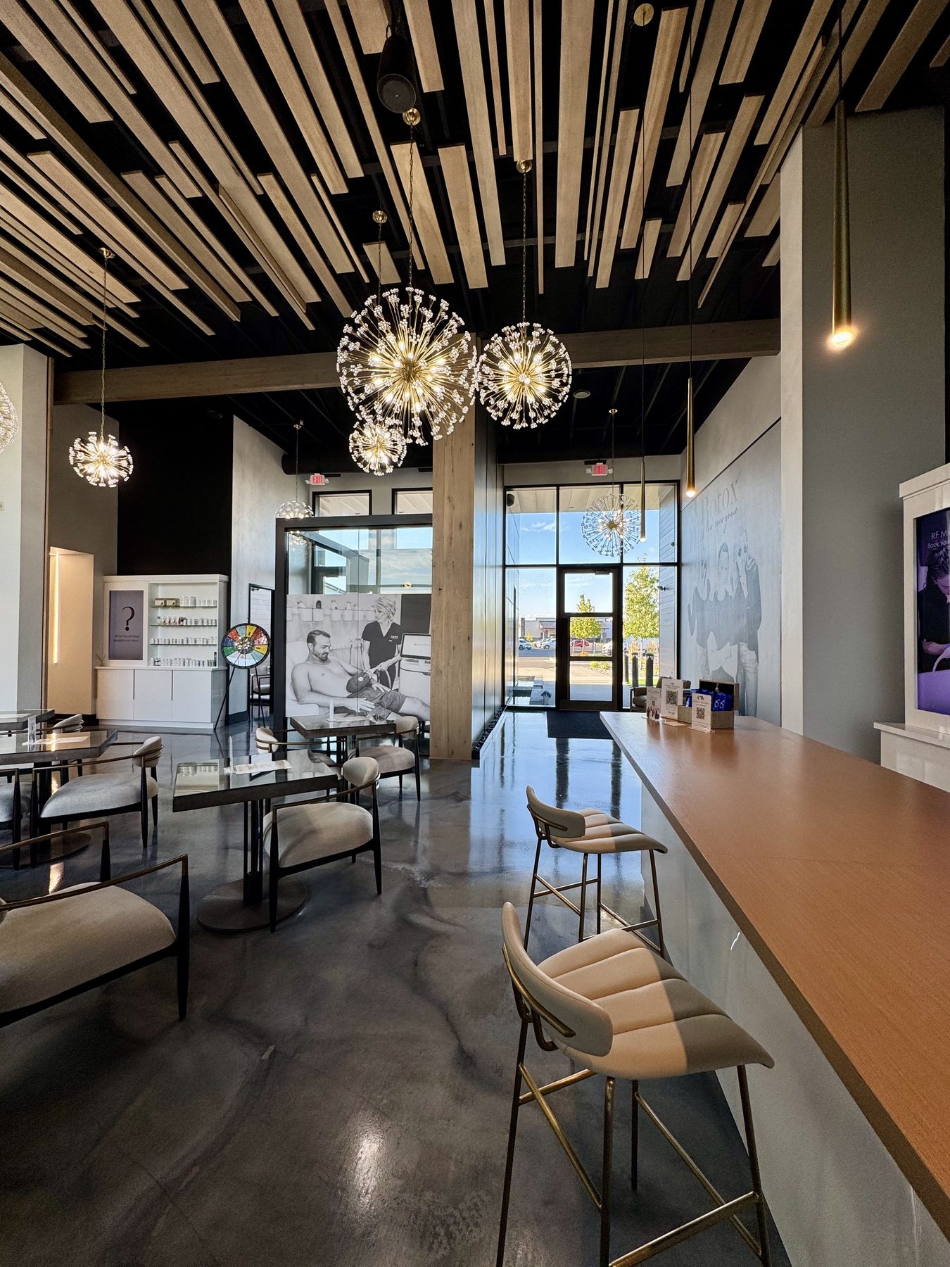 Lobby seating area with a slat ceiling and pendant lighting
