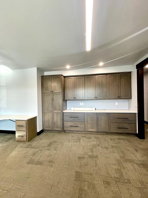 Office break area with cabinetry and clean carpet