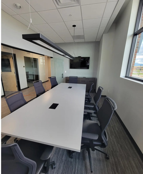 Conference room with a white table and a wall-mounted display